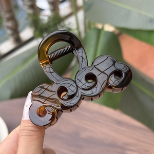 Dettaglio di un elegante fermaglio per capelli ambra tartarugato con design a nuvola