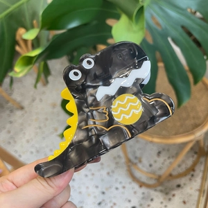 Pince à cheveux dinosaure en acétate gris foncé avec crêtes jaunes et liseré doré