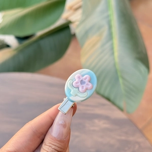 Haarclip van acetaat met roze bloem en blauw marmerpatroon op metalen eendenbekclip