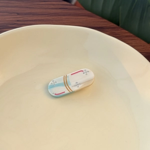 Sweet capsule-shaped acetate hair clip with blue and white design and fine rhinestone accents