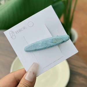 Macro detail of blue marble acetate hair clip with gold France Handmade lettering