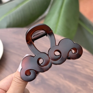 Dettaglio del fermaglio per capelli tartarugato marrone scuro con eleganti motivi a onde