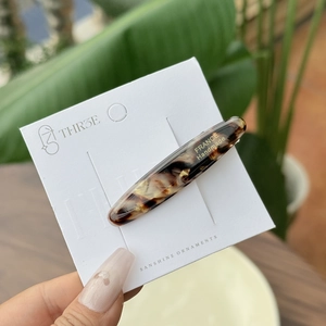 Detail of tortoise shell acetate hair clip with golden France Handmade lettering on card