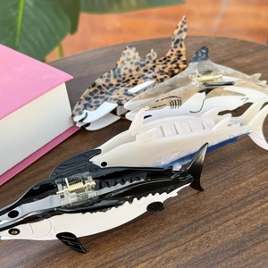 Detailed close-up of marine series tuna and shark acetate hair claws with gold springs