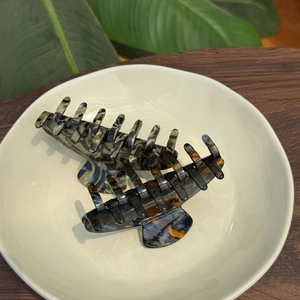 Detailed close-up of premium acetate hair claw clips in tortoise and blue marble finish