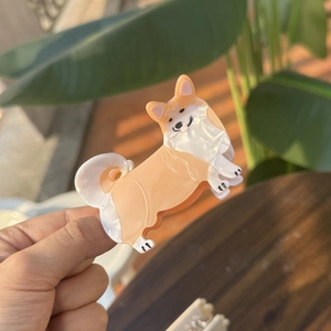 Close-up of Corgi shaped acetate hair claw clip with orange and white pearl texture
