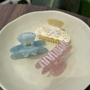 Three bow hair claws in macaron blue, yellow and pink with marble acetate and rhinestones