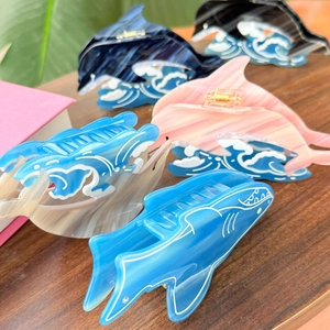 Détail de pinces à cheveux en acétate dauphin et requin avec texture marbre et vagues
