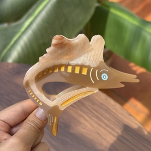 Chic marlin shaped acetate hair claw clip with brown marble texture and golden accents