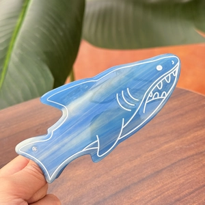 Détail de la pince à cheveux requin en acétate marbré bleu avec lignes et cristal
