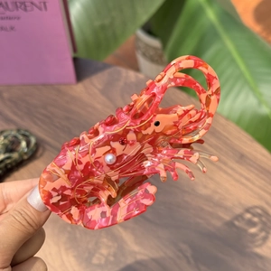 Shrimp shaped hair claw clip in orange marble acrylic with pearl and gold accents