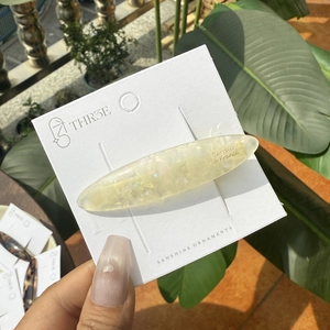 Pince à cheveux ovale allongée en acétate jaune avec paillettes irisées scintillantes