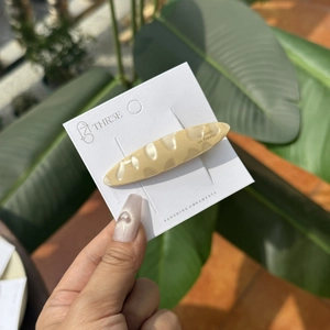 Détail d'une pince à cheveux créative en forme de baguette française sur carte