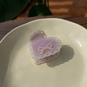 Dettaglio molletta a cuore viola con bordo in pizzo bianco e piccolo fiocco rosa