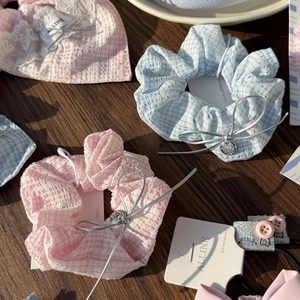 Spitzen-Haarschmuck-Set mit rosa und blauen Schleifen und Katzenanhängern auf Holz