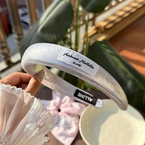 Detailansicht eines silbernen Schwamm-Stirnbandes mit Struktur und Hakuna Matata-Label