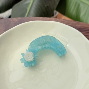 Blue marble acetic acid hair claw with white rose detail in a ceramic dish setting