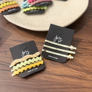Gros plan de barrettes à cheveux ondulées en acétate aux couleurs macaron doux