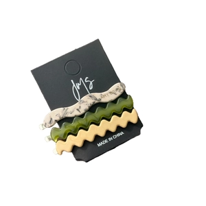 Lot de trois barrettes à cheveux ondulées en acétate beige marbré, vert olive et crème