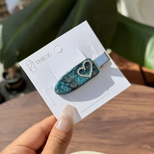 Haarclip van groenblauw marmerhars met hart-strass-steentjes op een kaart
