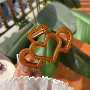 Pinza para el pelo ámbar translúcida con diseño de tres corazones calados
