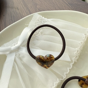 Brown elastic hair tie with heart-shaped amber resin pendant for high ponytails