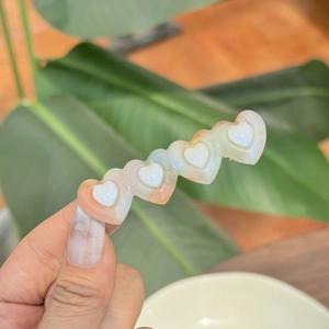 Colorful heart-shaped acetate hair clip with iridescent pearl finish and five-heart design