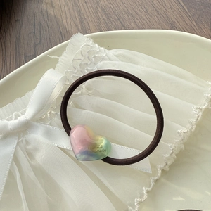 Detail of a handmade gradient heart hair tie on a lace background with macro texture