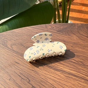 Detailansicht der Haarspange mit Blumenmuster und Strasssteinen auf Holztisch