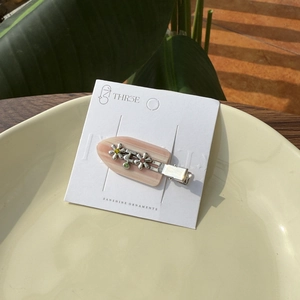 Barrette à cheveux en acétate avec fleurs et strass colorés sur carte blanche