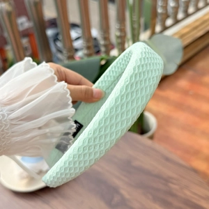 Detailed texture view of a thick mint green sponge headband with honeycomb fabric pattern