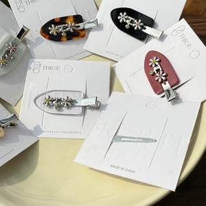 Vue détaillée de pinces à cheveux florales avec strass sur cartes de présentation