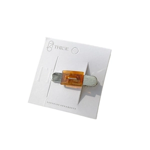 Vintage amber acetate hair clip with silver metal base on a white display card