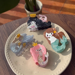 Detail of four acetate mermaid hair claws with pearlescent texture and marble patterns