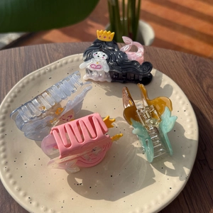 Set of four acetic acid mermaid hair clips in pastel colors on a ceramic plate