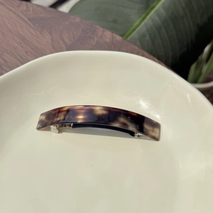 Close-up of tortoise shell pattern rectangle hair clip with golden handmade logo