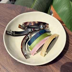 Detailed macro view of colorful acetate hair clips with vibrant marble and floral textures