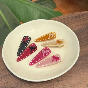 Set of 6 colorful acetate hair clips with bow detail and white stitched border accents