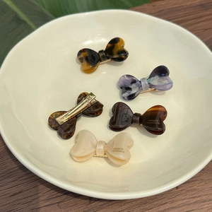 Détails des barrettes nœuds en acétate aux textures marbrées et coloris variés