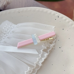 Fermaglio in acetato rosa con pietre marmorizzate su piatto in ceramica e pizzo