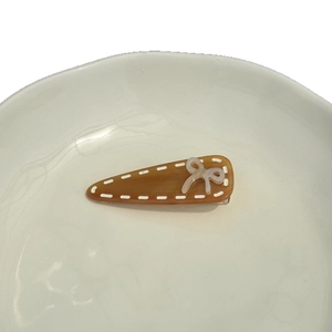 Caramel acetate triangle hair clip with white bow and stitch detail for women