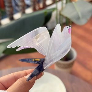 Translucent bird-shaped acetate hair claw clip with pearlescent marble texture for women