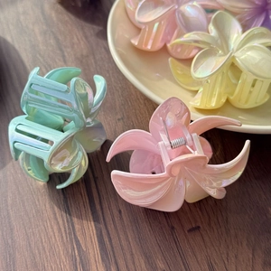 Details von makaronfarbenen Blumen-Haarklammern mit schillerndem Finish auf Tablett