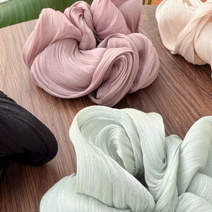 Vue détaillée de la texture du tissu plissé et de l'éclat des chouchous élastiques colorés