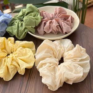 Detailed view of pastel macaron scrunchies with soft fabric texture and elegant pleats