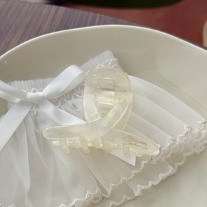 Close-up of elegant pearl white acetate hair clip with Barrette La France gold engraving