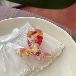 Elegant multicolor marble acetate hair claw clip for thick hair shown on a vintage plate