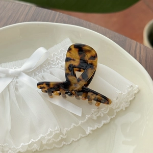 Close-up of tortoise shell pattern acetate hair claw clip with golden Barrette La France text