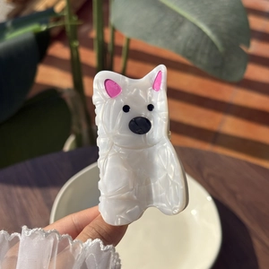 Haarklammer West Highland White Terrier aus weißem Acetat mit rosa Ohren in der Hand