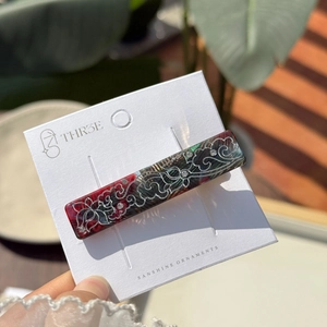 Macro view of rectangular hair clip with tortoise shell pattern and silver floral rhinestones